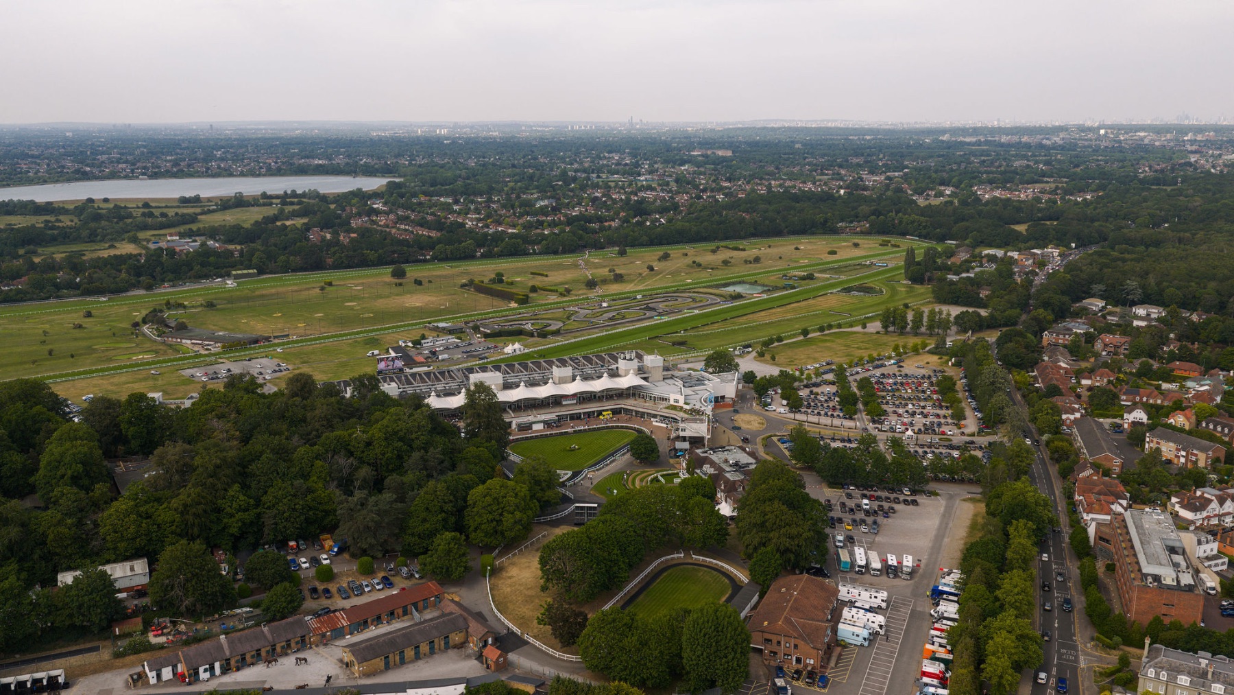 Open green countryside, lake and commons around Esher from the air