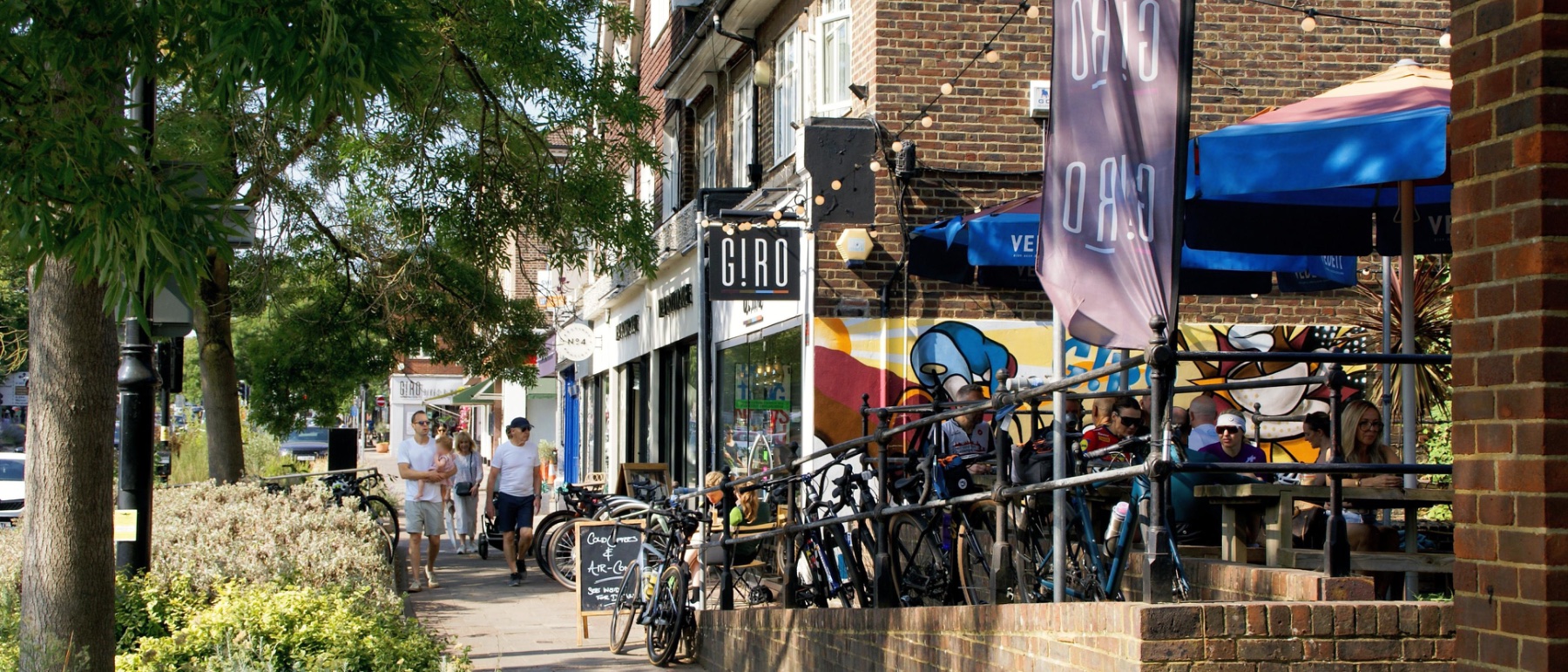 G!RO on Esher High Street, with people walking past and cyclists at the outdoor tables